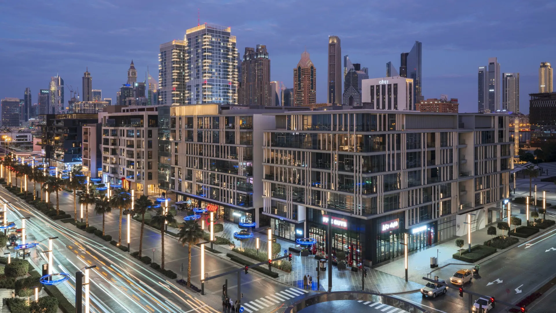 Completed City Walk buildings with restaurants, pedestrians and the Dubai skyline at dusk